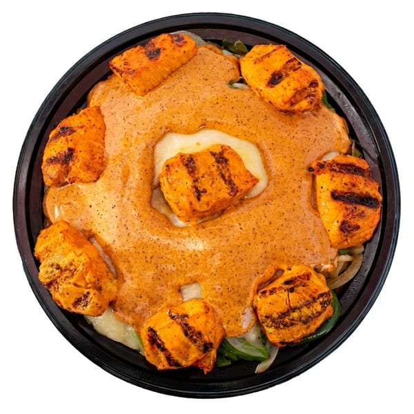 Overhead view of grilled chicken pieces and melted cheese covered in a creamy orange sauce.